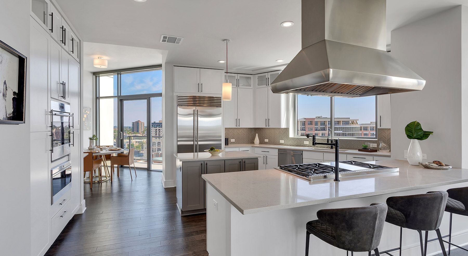 Wide open penthouse with kitchen leading into dining room and lots of natural light