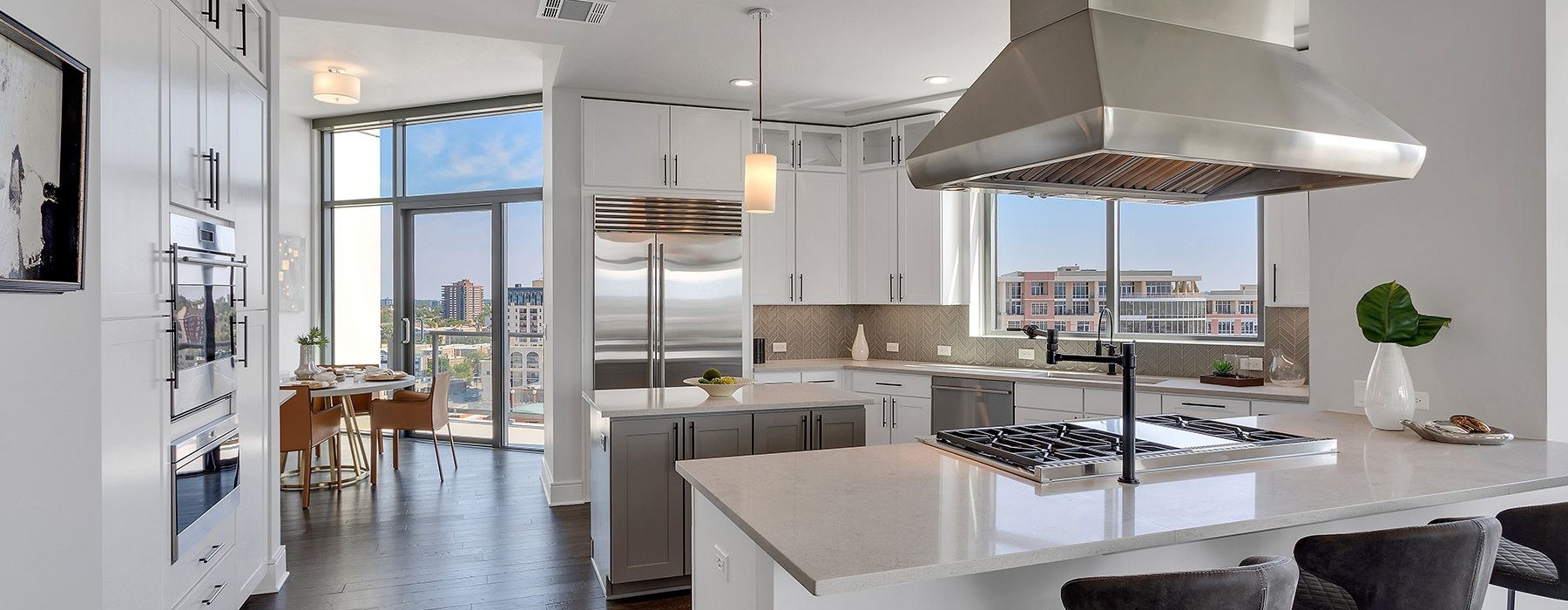 Wide open penthouse with kitchen leading into dining room and lots of natural light