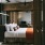 Spacious and well lit bedroom with wooden floors and orange accents
